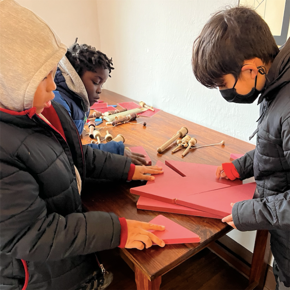 Three students play historic games at Old Salem